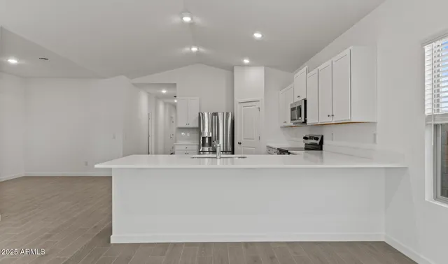 a kitchen with stainless steel appliances granite countertop a stove top oven a sink and dishwasher with wooden floor