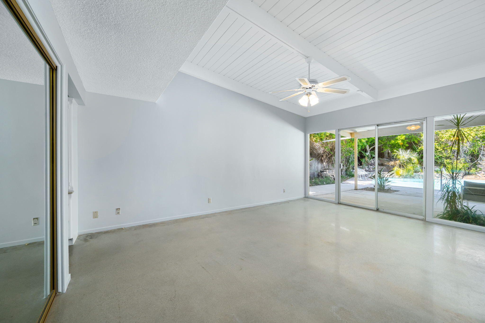1333 East Deepwell Road Palm Springs, CA 92264 - Photo 31 of 44 an empty room with chandelier fan and windows