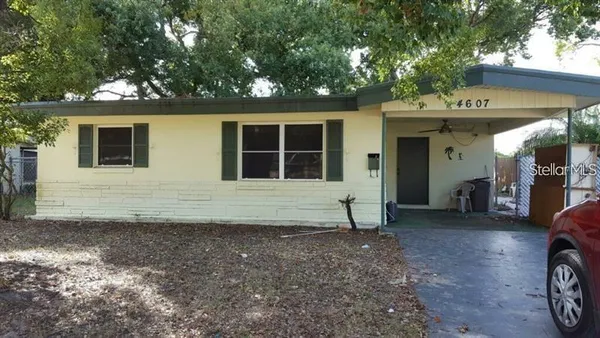 a view of a house with a yard and wooden fence