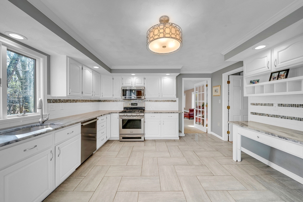 315 Candlestick Road North Andover, MA 01845 - Photo 16 of 42 a large white kitchen with granite countertop a stove and a sink