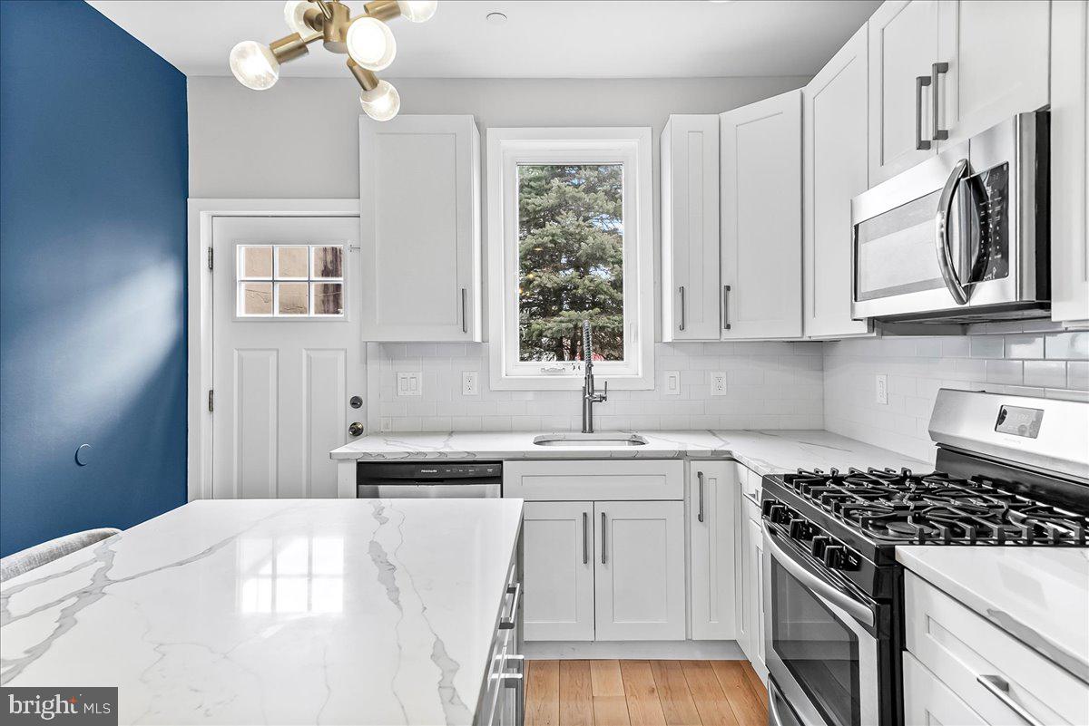 2615 East Letterly Street Philadelphia, PA 19125 - Photo 11 of 36 a kitchen with stainless steel appliances a white stove top oven and a sink