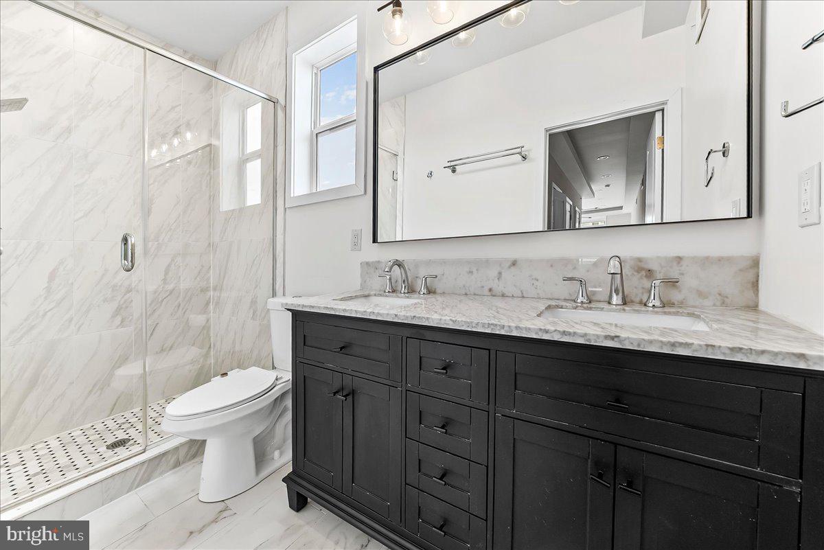 2615 East Letterly Street Philadelphia, PA 19125 - Photo 23 of 36 a bathroom with a granite countertop sink a toilet and a mirror