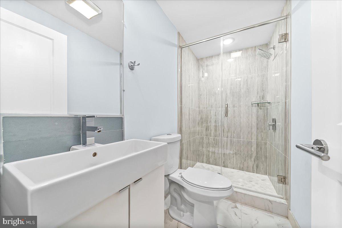 2615 East Letterly Street Philadelphia, PA 19125 - Photo 32 of 36 a bathroom with a sink a toilet a shower and a mirror
