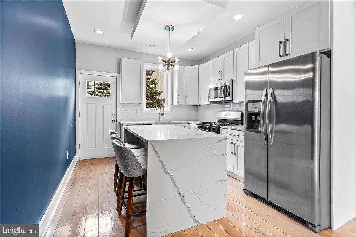 2615 East Letterly Street Philadelphia, PA 19125 - Photo 9 of 36 a kitchen with kitchen island a counter top space a refrigerator and stainless steel appliances