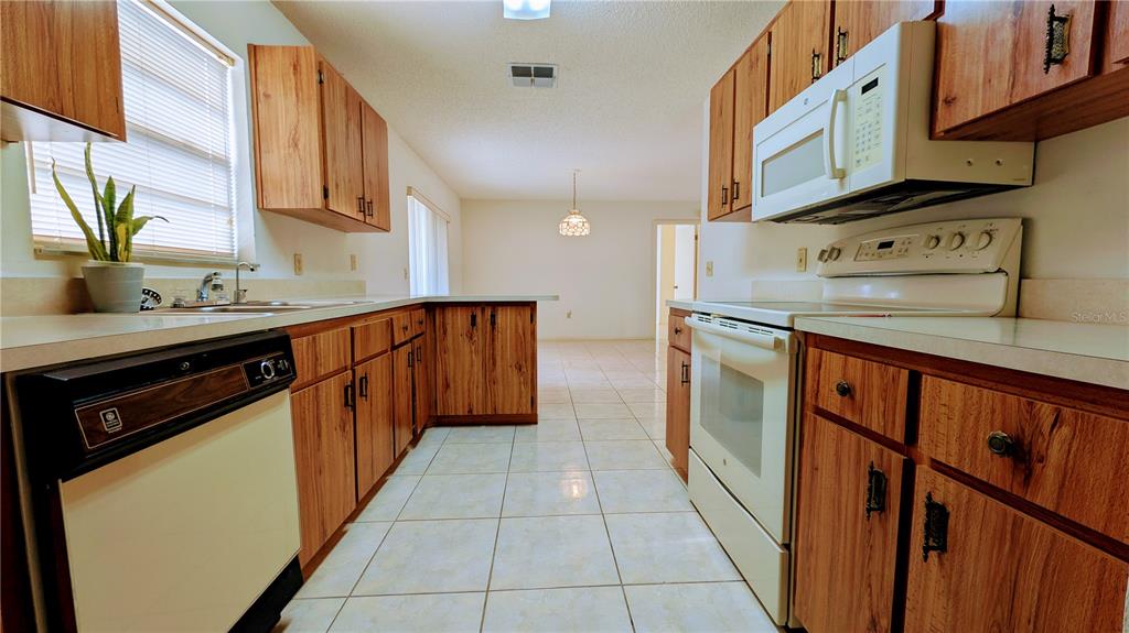 11438 Palomar Street Spring Hill, FL 34609 - Photo 19 of 37 a kitchen with stainless steel appliances granite countertop a sink stove and cabinets