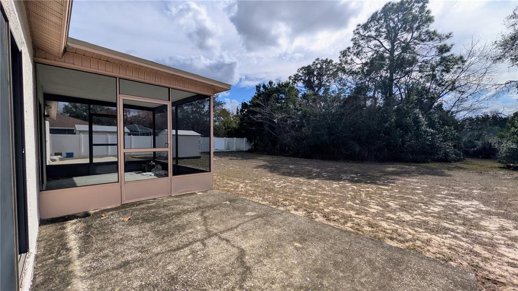 11438 Palomar Street Spring Hill, FL 34609 - Photo 37 of 37 a view of a backyard with wooden fence and large trees