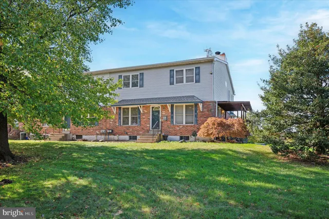 a front view of a house with a garden and trees
