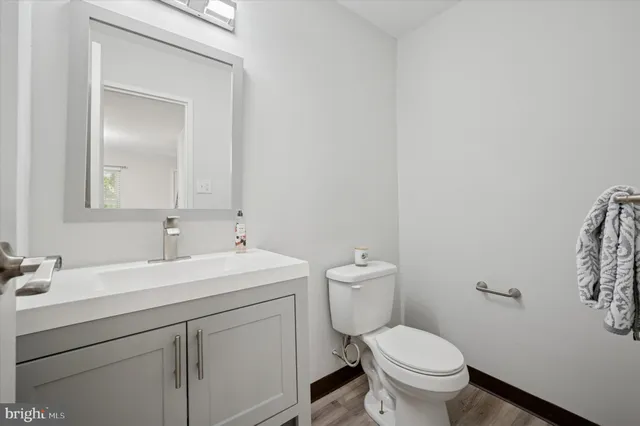 a bathroom with a toilet sink vanity and mirror