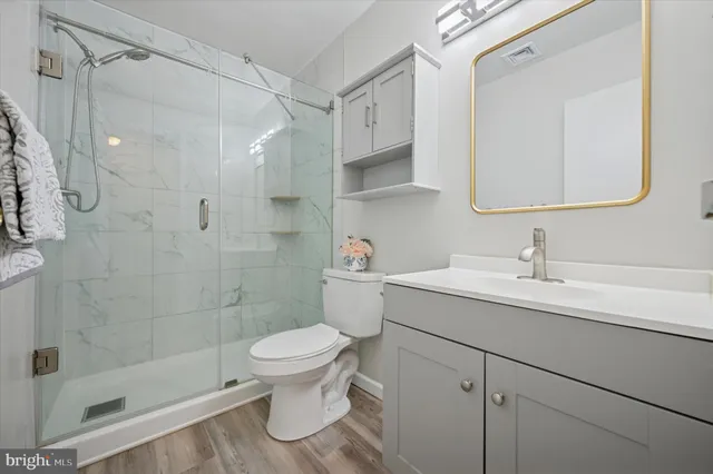 a bathroom with a sink a toilet and shower