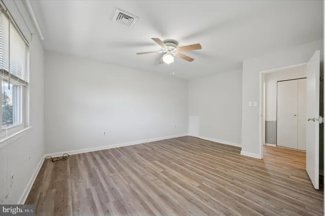 wooden floor in an empty room with a window