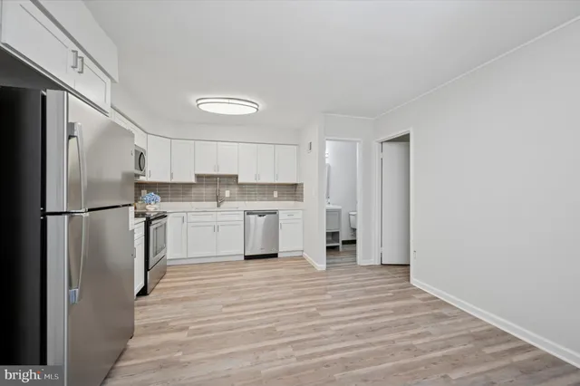 a kitchen with stainless steel appliances granite countertop a refrigerator and a stove top oven