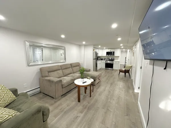 a living room with furniture and a wooden floor