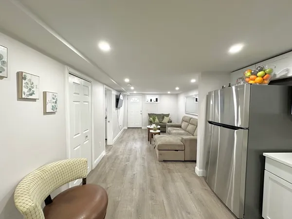 a kitchen with stainless steel appliances a refrigerator and a couch