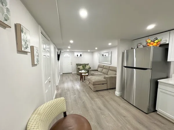 a living room with furniture and a refrigerator