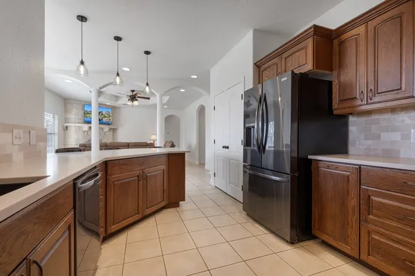 a open kitchen with stainless steel appliances granite countertop a refrigerator and a sink