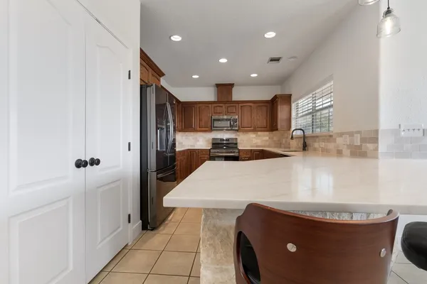 a kitchen with stainless steel appliances granite countertop a refrigerator and a sink