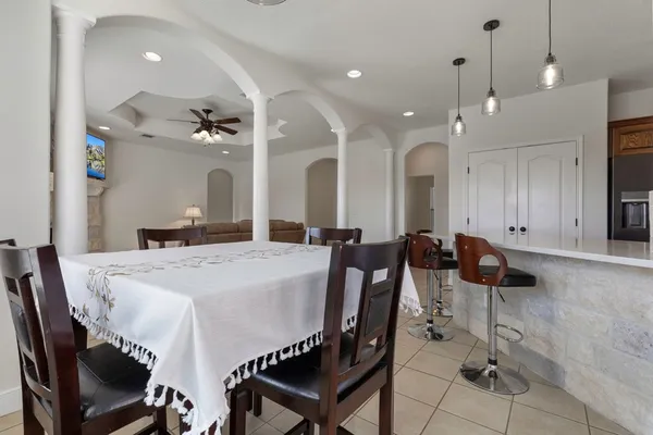 a view of a a dining room with furniture and chandelier