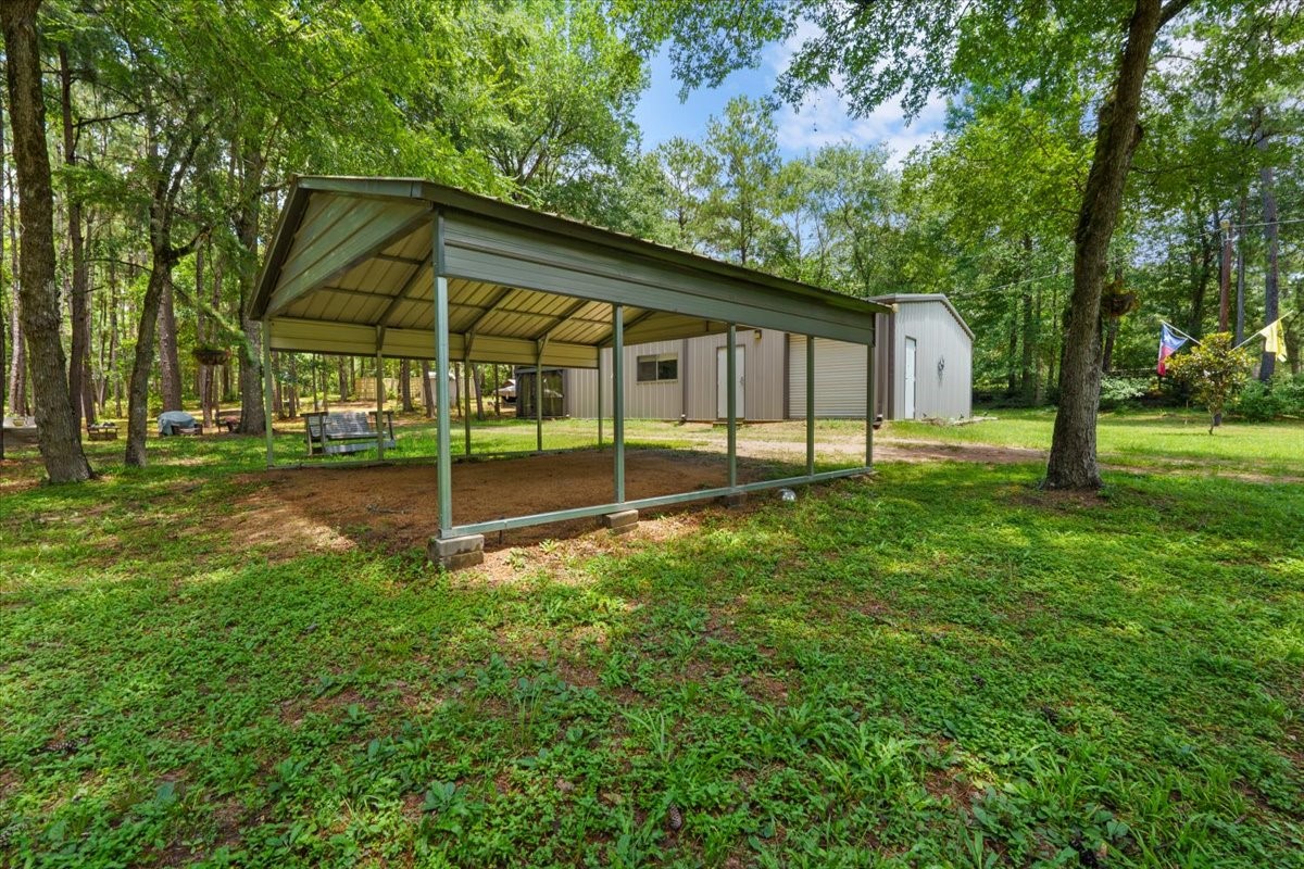 16375 Grand Flower Road Plantersville, TX 77363 - Photo 16 of 50 a view of a house with backyard and a tree