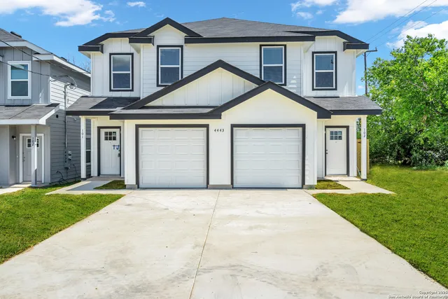 a front view of a house with a garden and yard