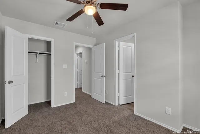 an empty room with closet and windows