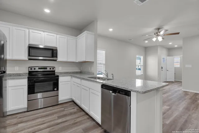 a kitchen with stainless steel appliances kitchen island granite countertop a stove and a sink