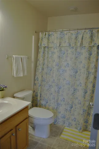 a bathroom with a granite countertop toilet a sink and a shower
