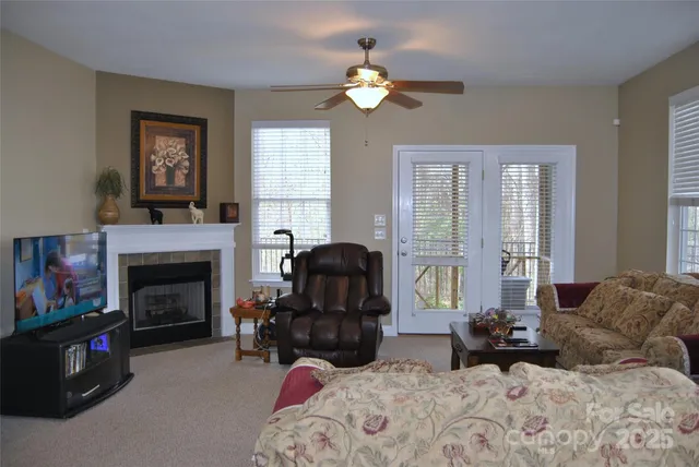 a living room with furniture a fireplace and a window