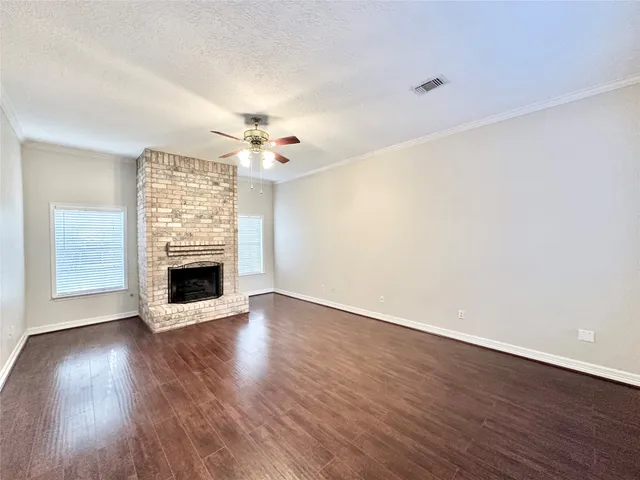 a view of a livingroom with wooden floor and a fireplace