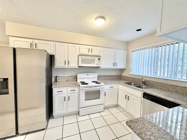 a kitchen with a stove a sink and a refrigerator