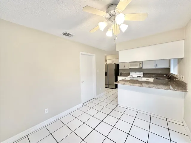 a large white kitchen with a sink and cabinets