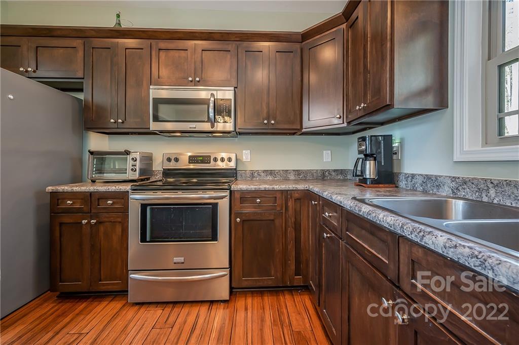 103 Christopher Road Tryon, NC 28782 - Photo 6 of 45 a kitchen with stainless steel appliances granite countertop a stove a sink and a microwave