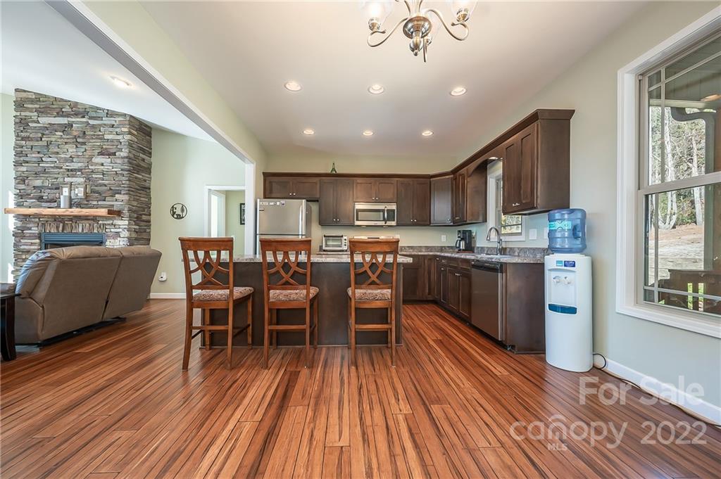 103 Christopher Road Tryon, NC 28782 - Photo 7 of 45 a kitchen with stainless steel appliances a dining table chairs and wooden floor
