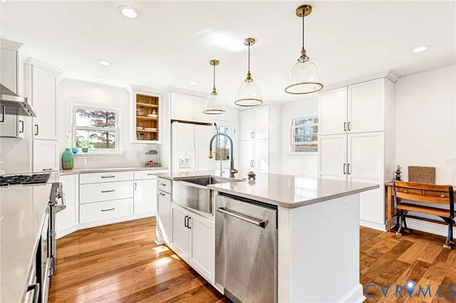 a kitchen with stainless steel appliances a sink a stove a center island and a window