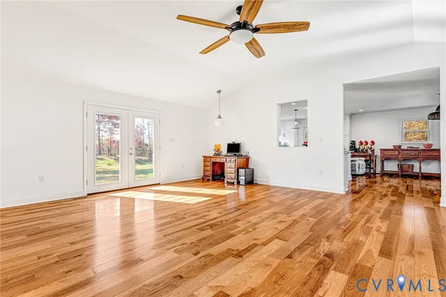 a kitchen with stainless steel appliances kitchen island granite countertop a refrigerator a stove a sink dishwasher and white cabinets with wooden floor