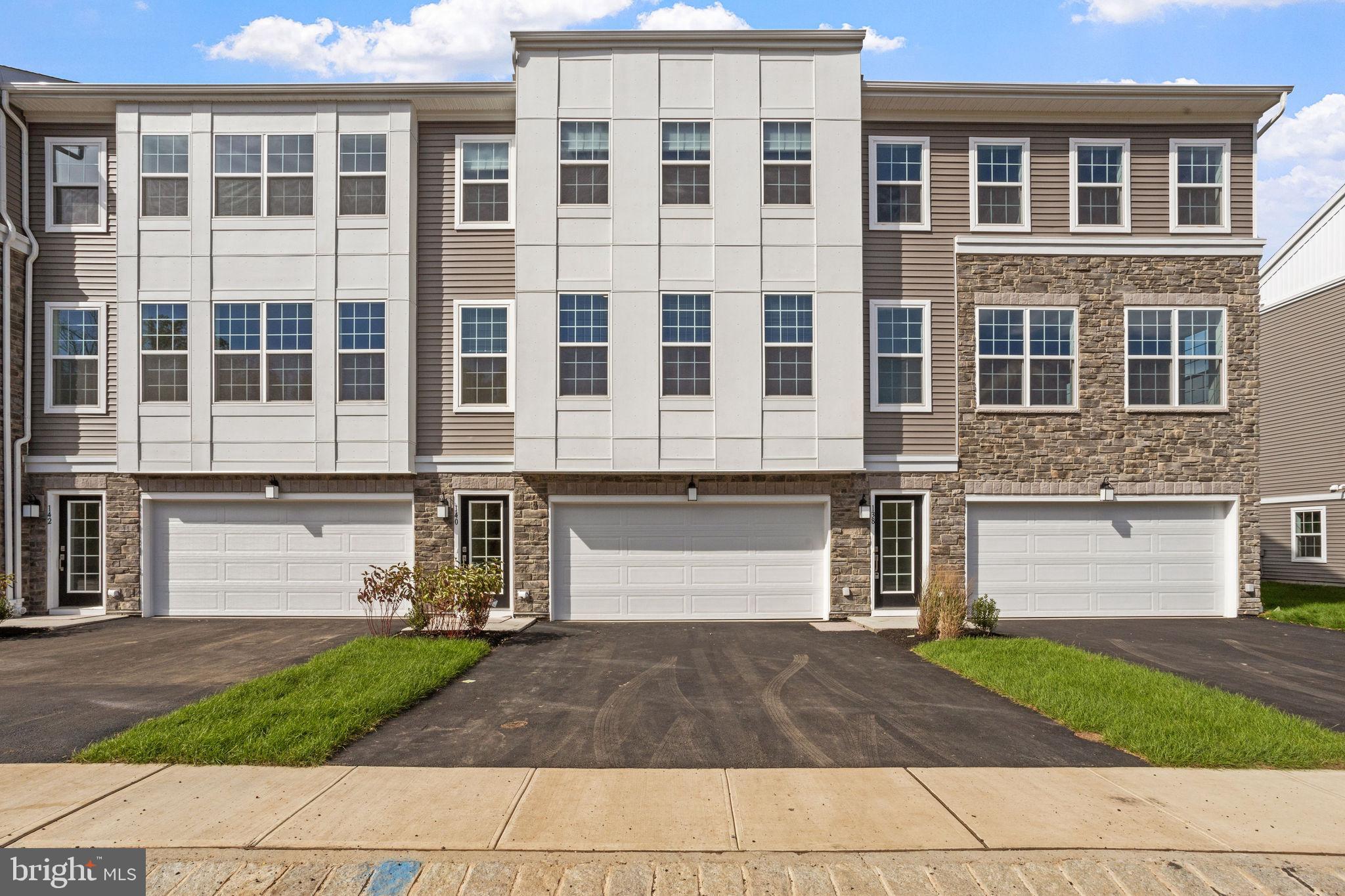 a front view of a house with a yard and a garage