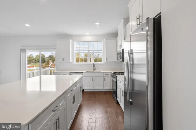 a kitchen with a refrigerator a sink and windows