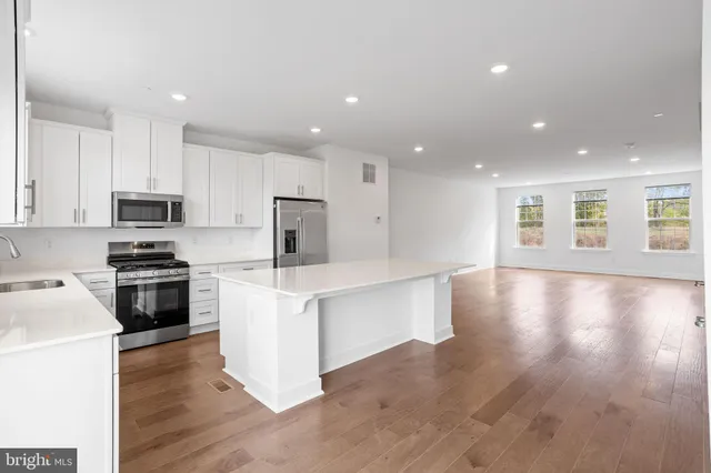 a kitchen with a refrigerator and a stove top oven