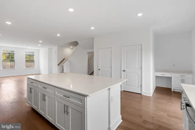 a kitchen with a sink and wooden floor