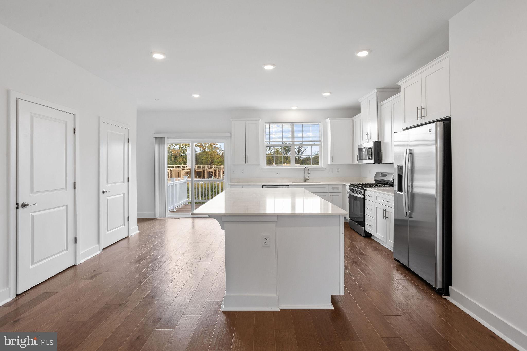 142 ADA Hightower Avenue Pennington, NJ 08534 - Photo 3 of 46 a kitchen with stainless steel appliances granite countertop a refrigerator a sink dishwasher a stove and white countertops with wooden floor