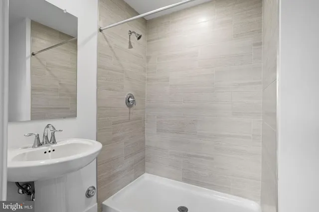 a bathroom with a sink a shower and a mirror