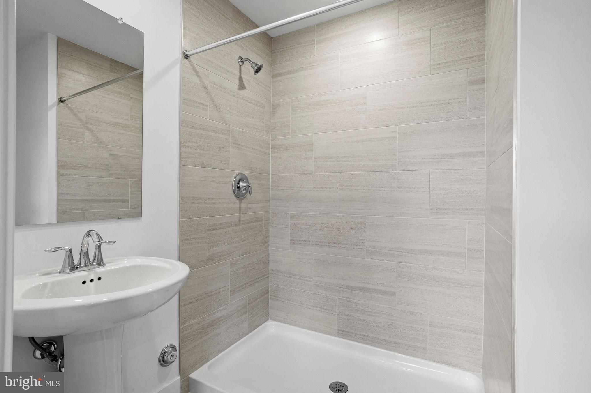 142 ADA Hightower Avenue Pennington, NJ 08534 - Photo 37 of 46 a bathroom with a sink a shower and a mirror