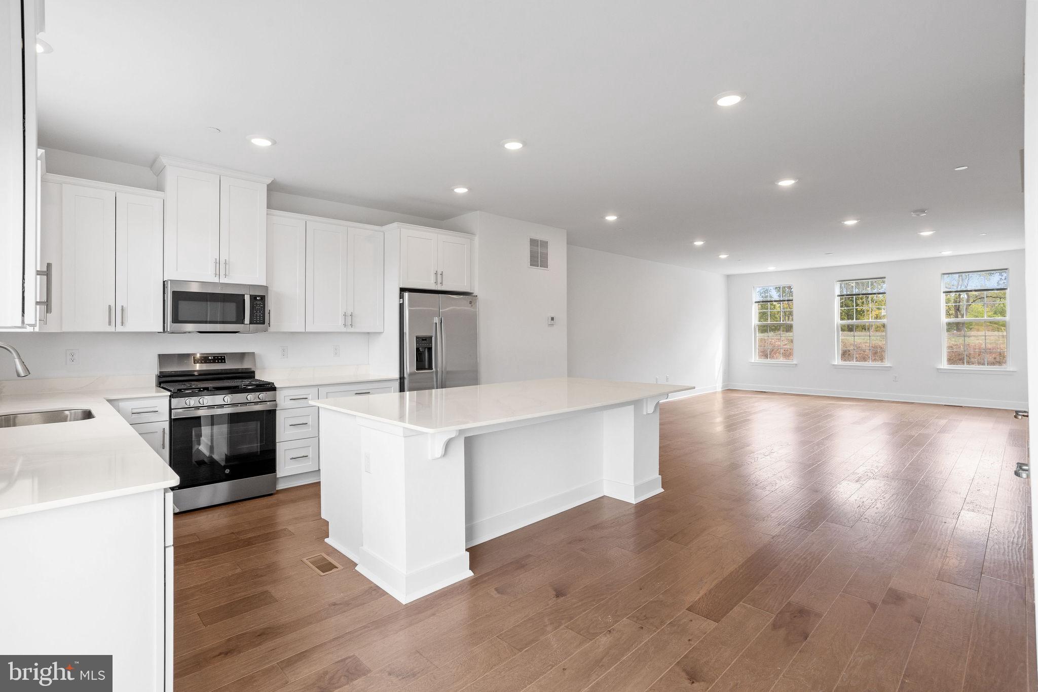 142 ADA Hightower Avenue Pennington, NJ 08534 - Photo 5 of 46 a kitchen with a refrigerator and a stove top oven