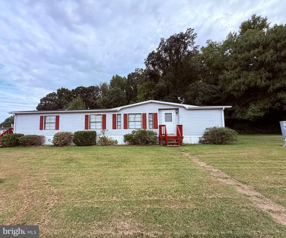 a view of a yard in front of a house with large tree