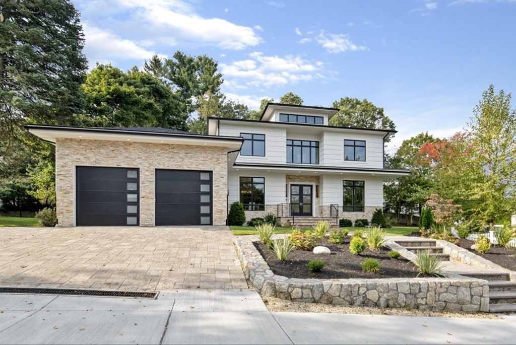a front view of a house with porch couches and trees