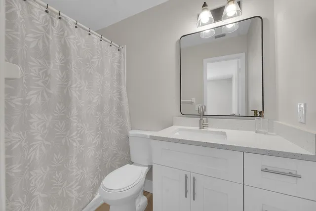 a bathroom with a toilet a sink and a mirror