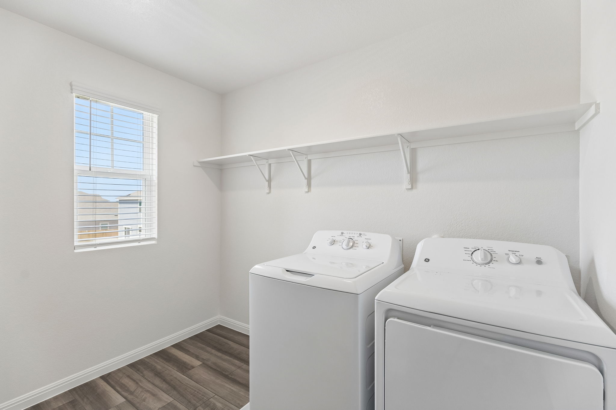 550 Thistle Lane Maxwell, TX 78656 - Photo 24 of 29 Laundry room with dark wood finished floors and washer and clothes dryer
