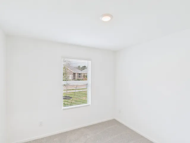 a view of a house with a yard and a large tree front of it