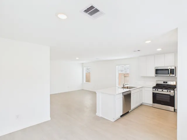 a kitchen with stainless steel appliances and white cabinets