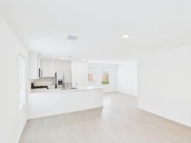 a large white kitchen with cabinets and a sink