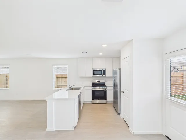a kitchen with stainless steel appliances granite countertop a refrigerator sink and stove